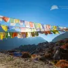 Snowy mountains under a clear blue sky above the rugged, stone-strewn Langtang Valley.