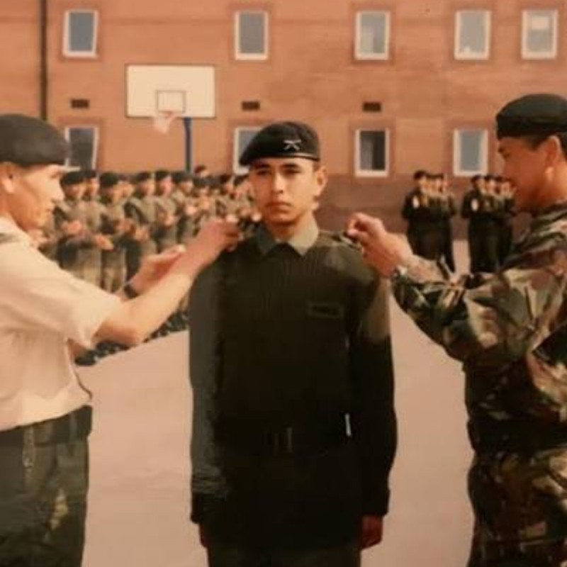 Nirmal Purja during his early days serving in the British Army, standing in uniform while receiving military insignia during a formal ceremony.ce years.