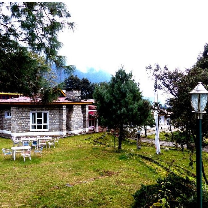 Lukla Airport Resort with garden seating and trees in the Everest region