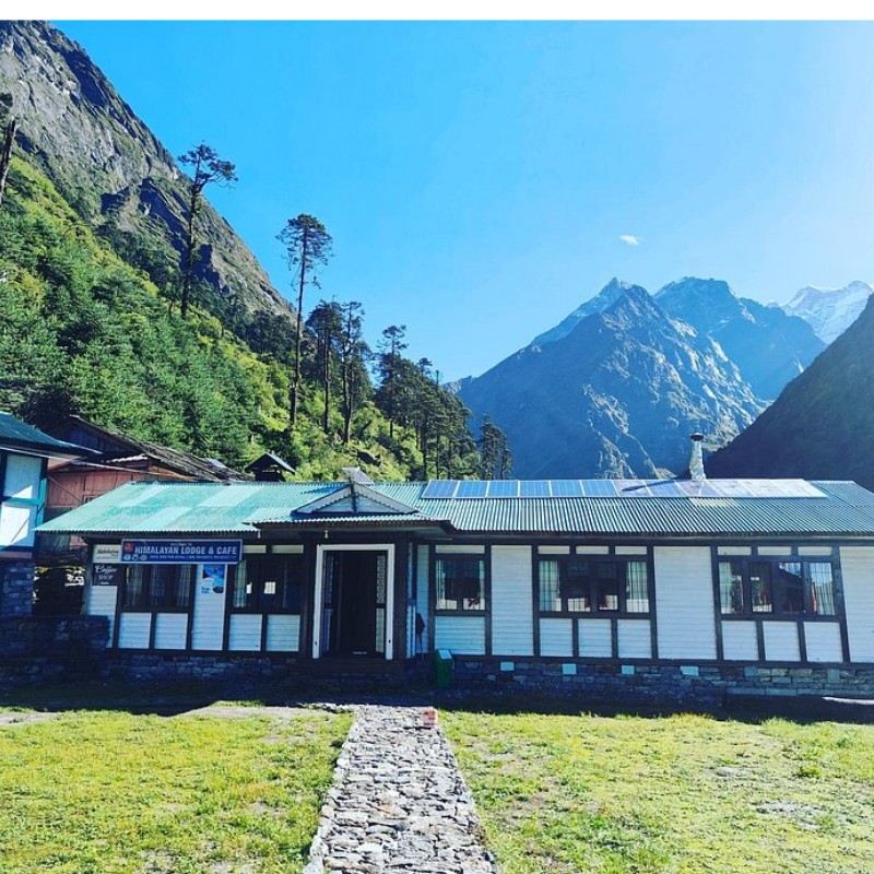Budget tea house lodge in Lukla with mountain scenery and green hillside