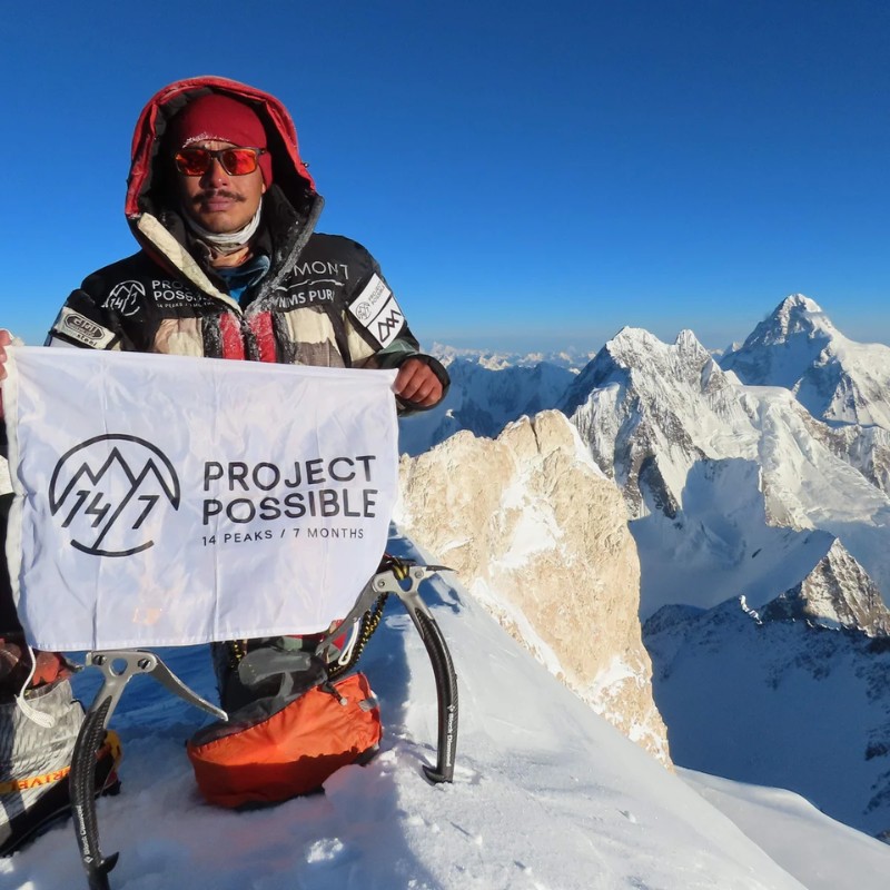 Nirmal Purja holding the Project Possible flag on the summit of Manaslu during his record-breaking mission to climb all 14 of the world's 8,000-meter peaks in six months.