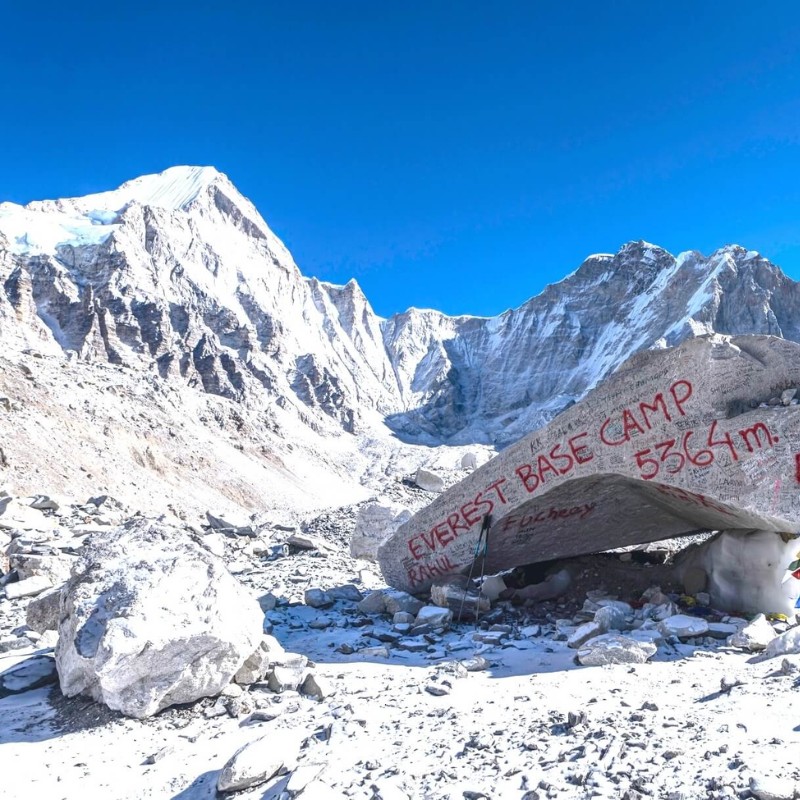 Everest Base Camp marker surrounded by snowy Himalayan peaks in Nepal.