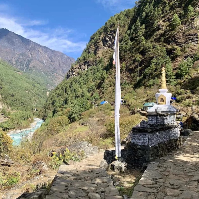Trail from Lukla to Phakding beside the Dudh Koshi River with a Buddhist stupa