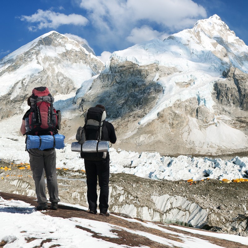 Trekkers standing on Kala Patthar overlooking Everest and the Khumbu Glacier in Nepal.